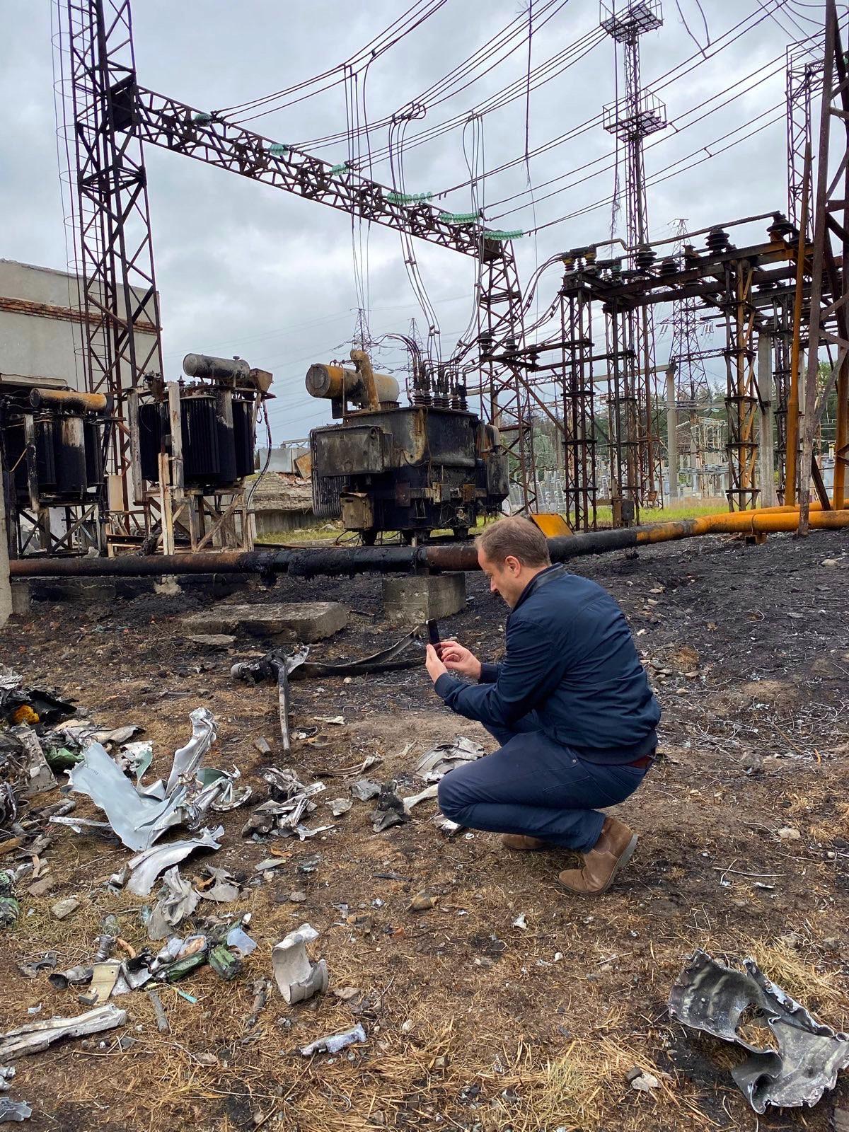 Nigel Pavoas is bent down among the remains of a power station in Kharkiv.
