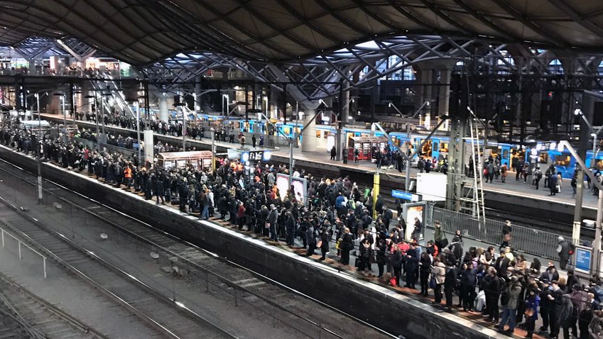 Crowds of people wait on a platform for trains at Southern Cross Station in Melbourne.