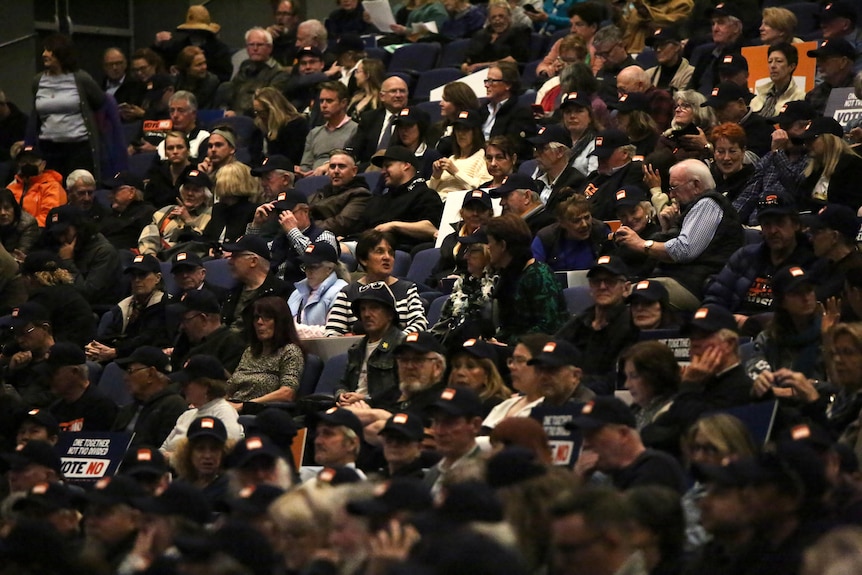 A crowd of people gathered at a seated event in an auditorium.