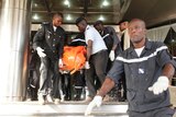 Medical officers remove bodies of Mali attack victims on a stretcher.