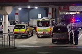 Police vehicles and officers in a carpark with ambulances at Ipswich Hospital.