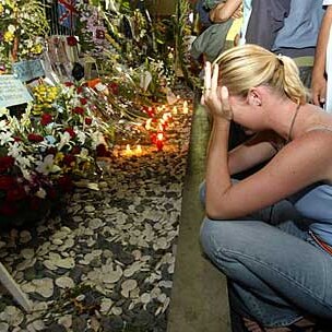 A woman weeps in front of a makeshift memorial at the former Sari club.