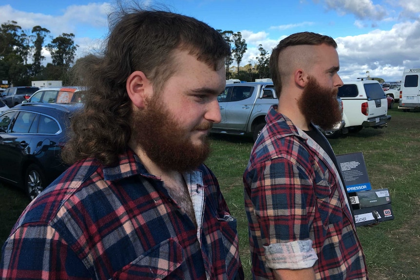 Two men wearing matching shirts with mullets