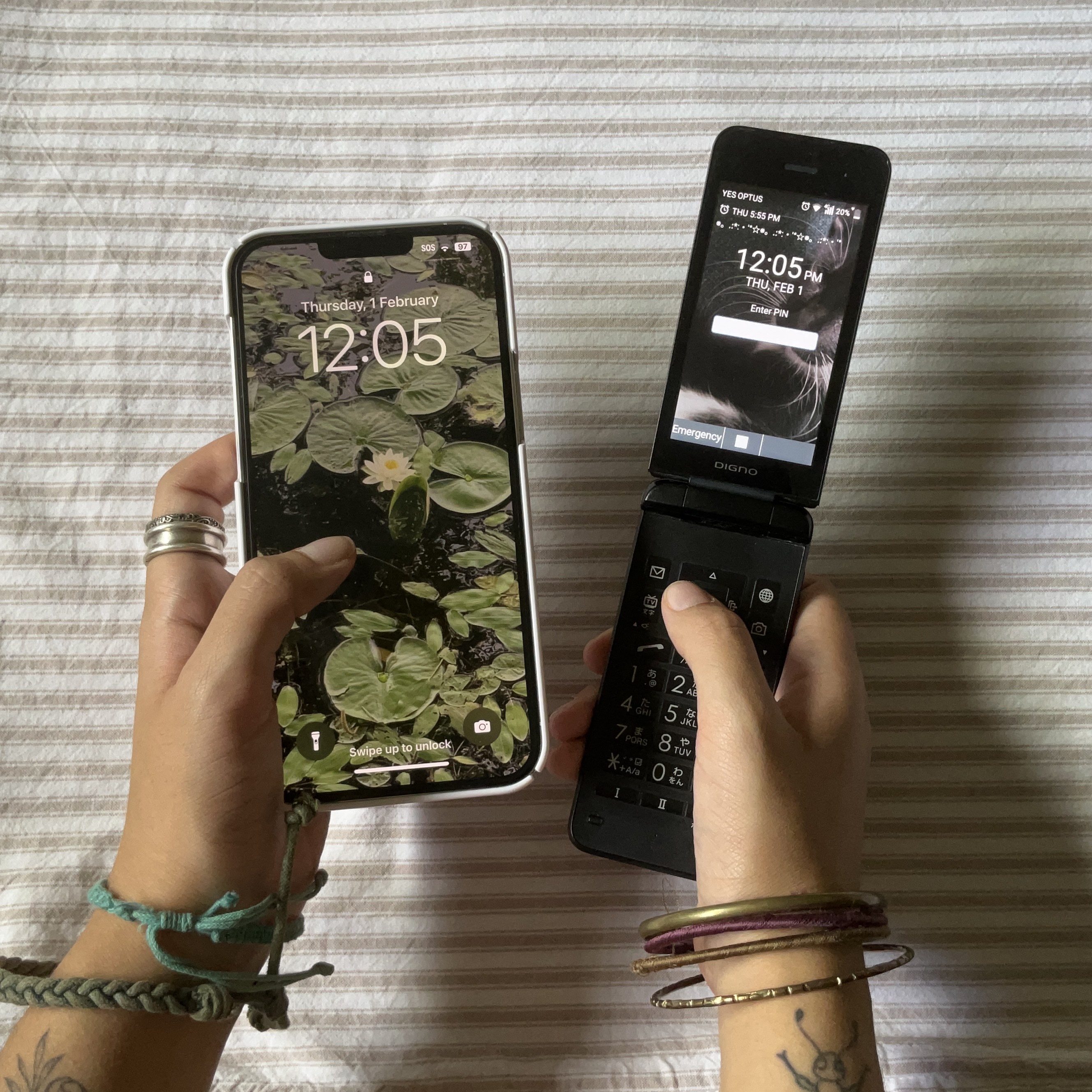 A close up of a person's hands, one holding an iPhone and one holding a small flip phone.