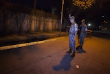 Bangladeshi police stand guard at the site where an Italian aid worker was gunned down in Dhaka