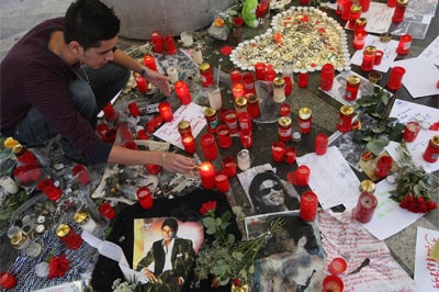 A man in Berlin, Germany, lights a candle at a makeshift shrine to Michael Jackson
