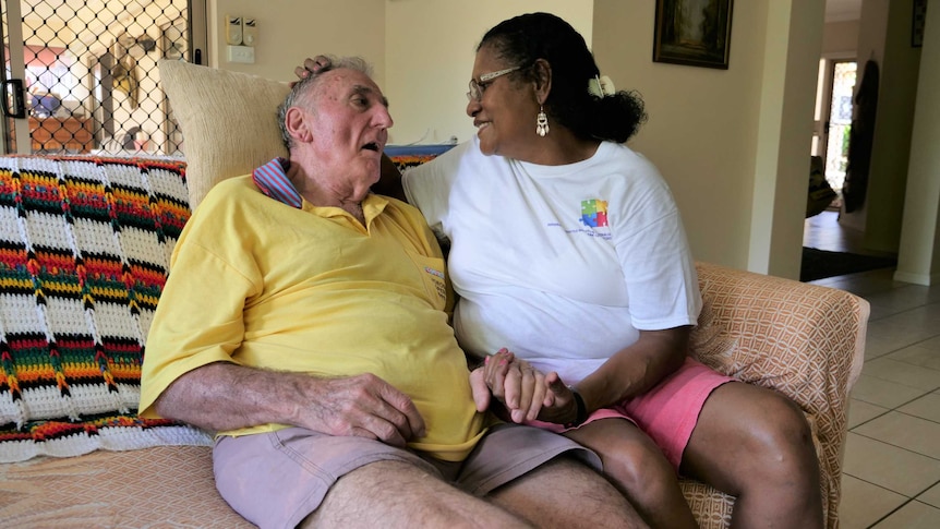 An elderly man and woman sitting on a sofa