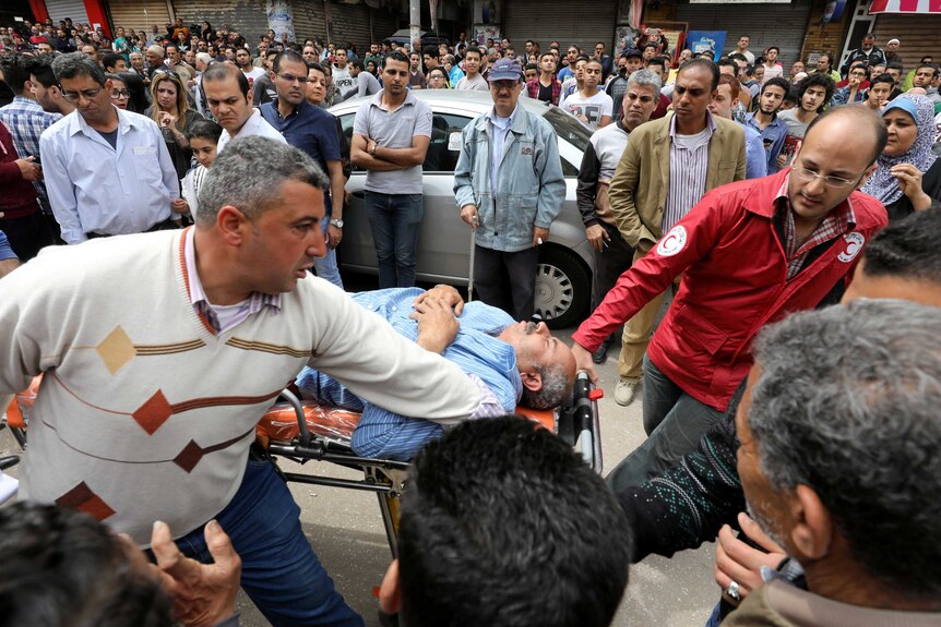 A victim is seen on a stretcher after a bomb went off at a Coptic church in Tanta, Egypt.