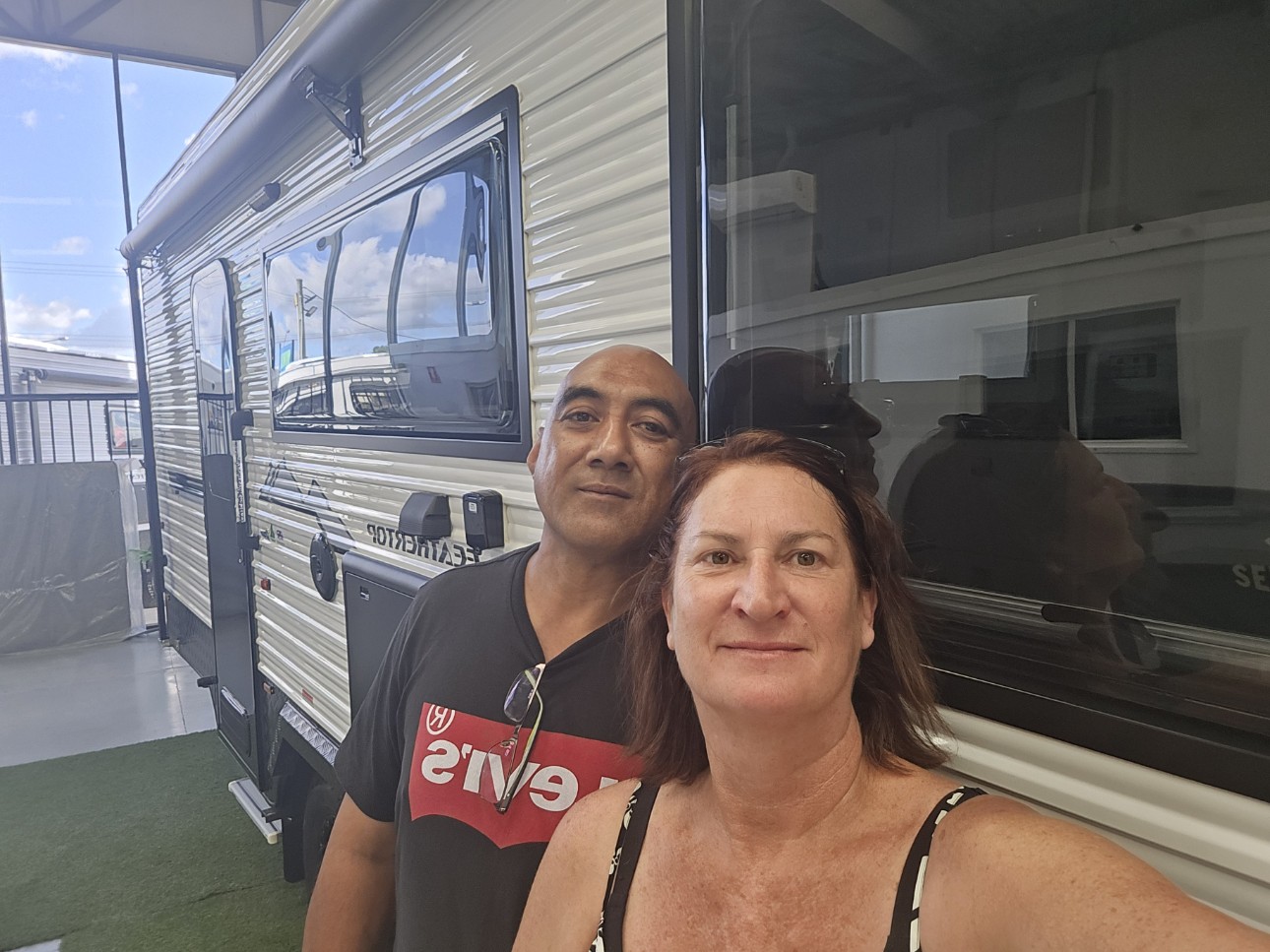 Un hombre y una mujer se encuentran frente a una casa móvil.