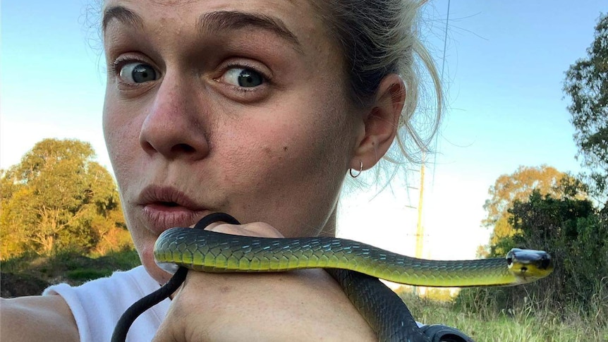 Snake-catcher Bridget Thomson holds a tree snake in a story about how to snake-proof your home.
