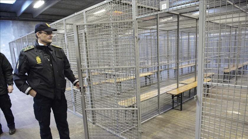 A police officer opens one of the 37 metal cages installed in a former Carlsberg beer depot