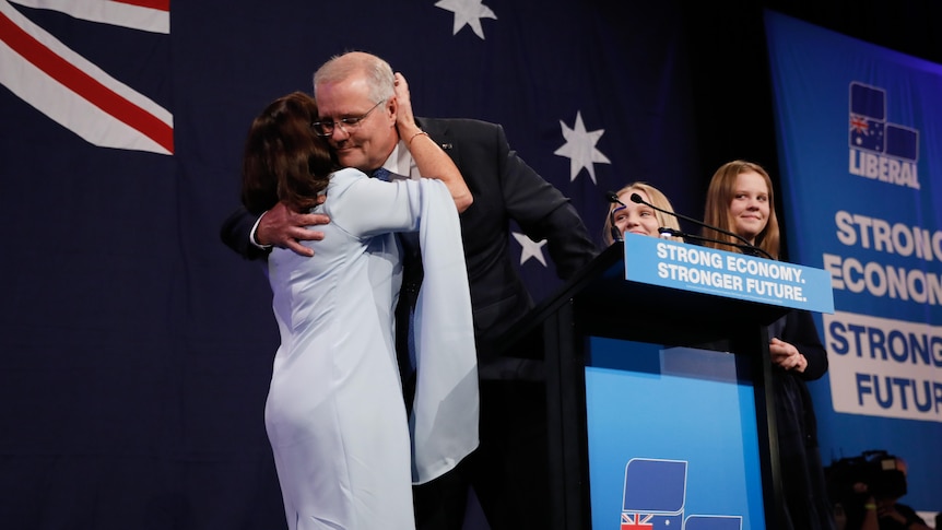 Scott Morrison leans down to hug his wife Jenny at the lecturn during a concession speech