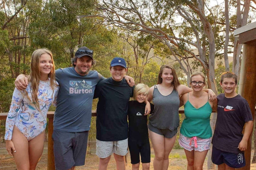 Greg Matchett and Tracey Corbin-Matchett pose for a photo with their children and two nephews on the balcony of the property.