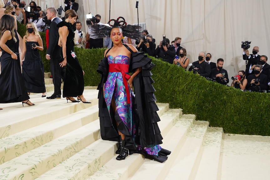 Woman in a gown standing on the stairs at an event