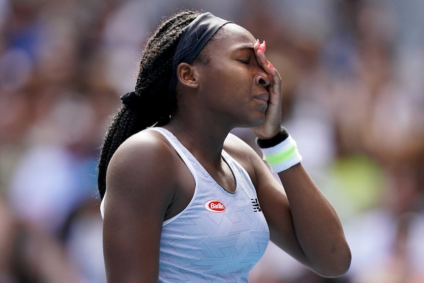 A female tennis player holds her face in frustration at the Australian Open.