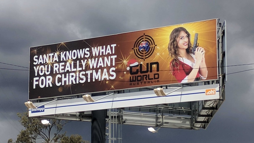 The Gunworld billboard with a picture of a woman holding a pistol.