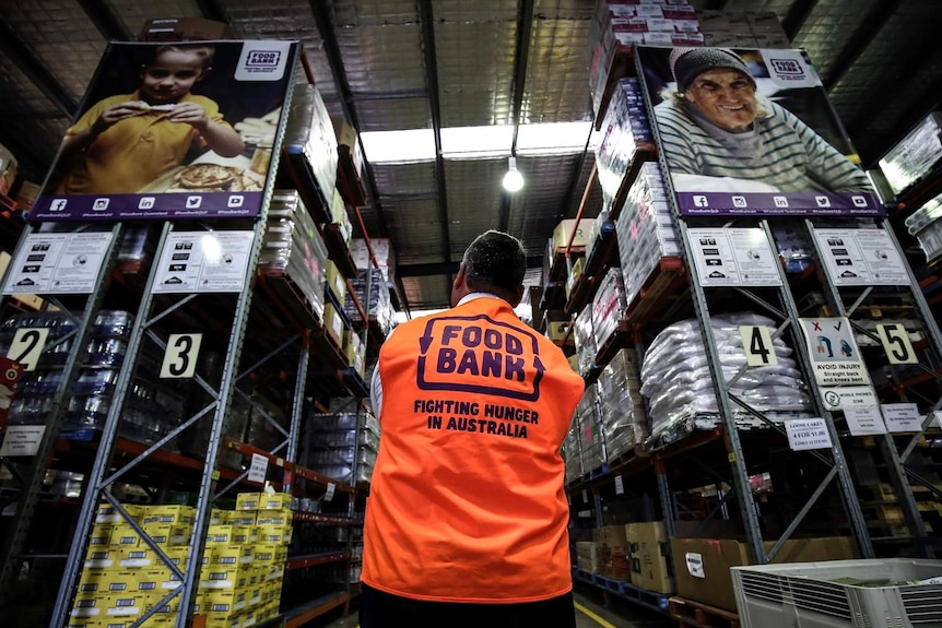 Foodbank Queensland CEO Michael Rose stands looking at shelves of salvaged food waste in the Foodbank warehouse in Brisbane