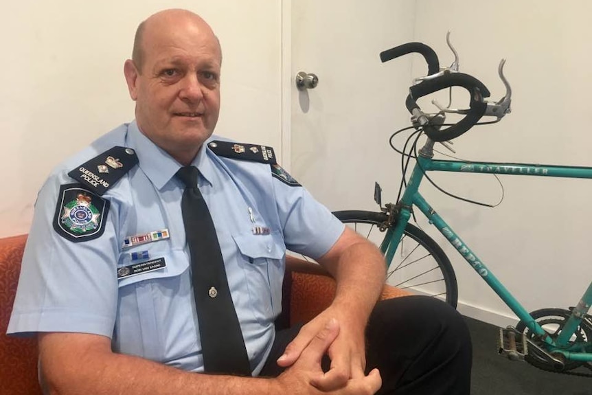Capricornia District Inspector Ron Van Saane sits on a chair in front of a stolen bike.