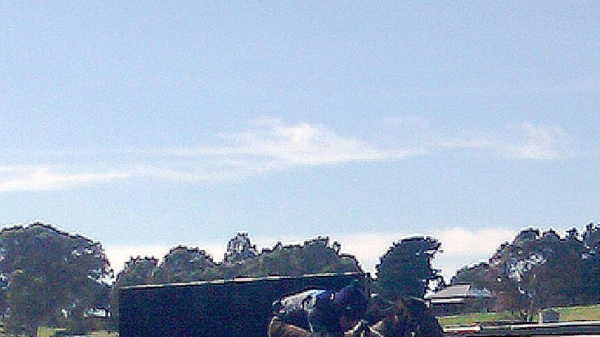 A rider and horse clear a jump at trials at Oakbank