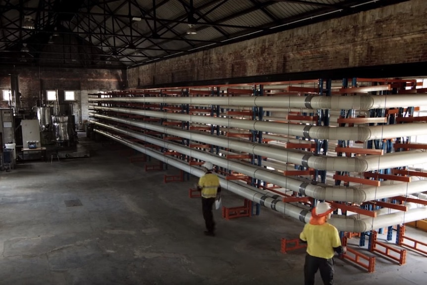 A 1.2-kilometre network of above ground pipes coiled upon itself in a warehouse.