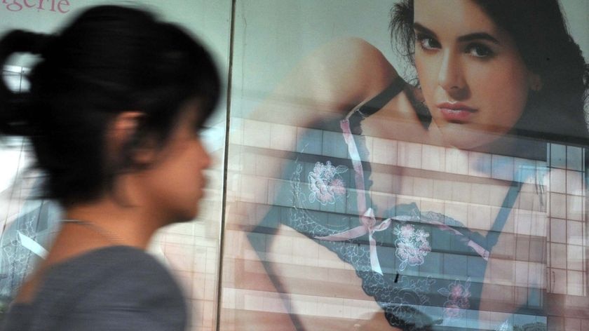 A woman walks past a lingerie advertisement at a shopping mall (AFP: Bay Ismoyo)