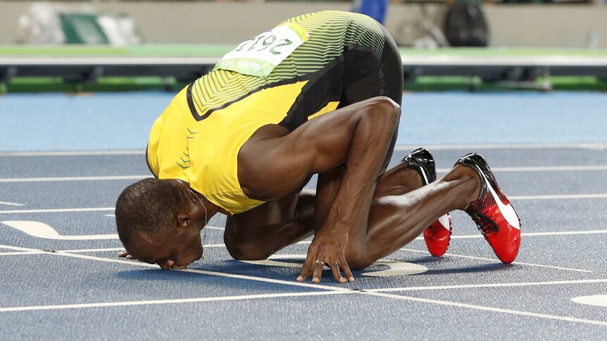 Usain Bolt kisses the track after winning 200m gold