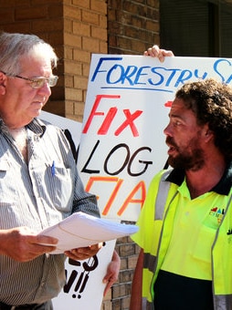 Two men talk at an election booth.