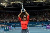 America's Serena Williams celebrates with the trophy after winning the Brisbane International title.