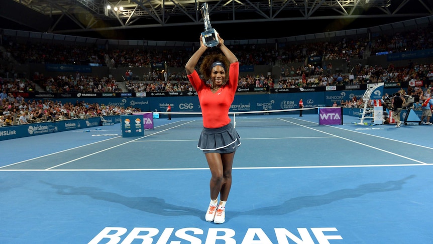 America's Serena Williams celebrates with the trophy after winning the Brisbane International title.