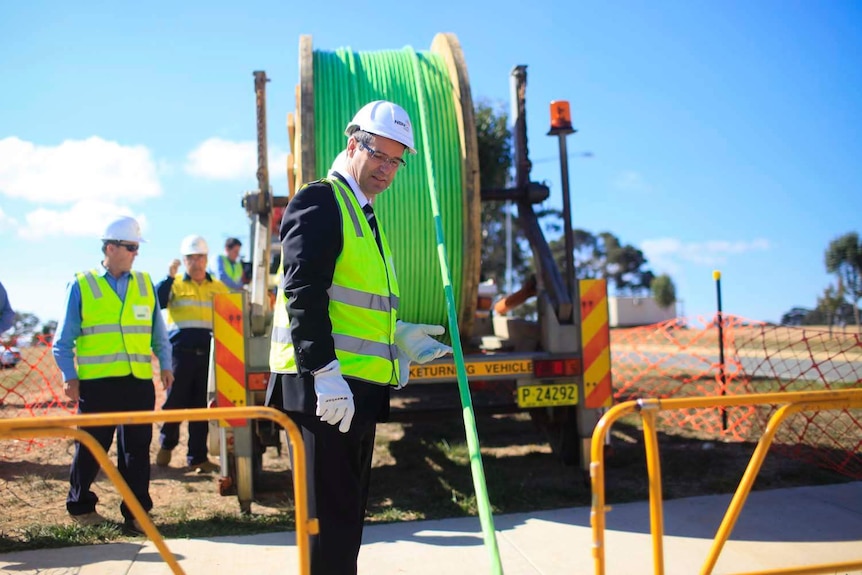 Stephen Conroy holds a fibre-optic cable