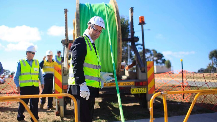 Stephen Conroy holds a fibre-optic cable