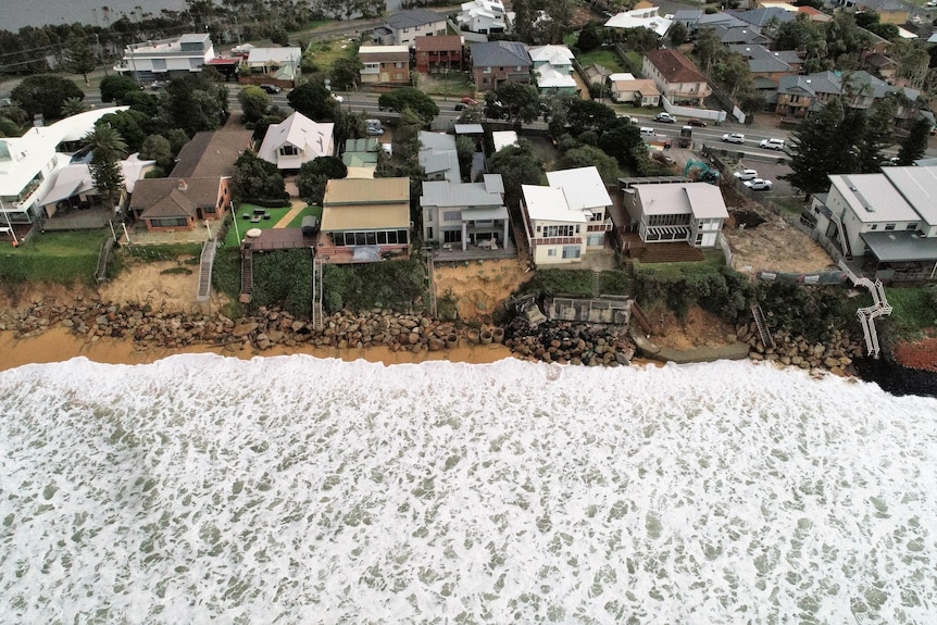 Waves close to houses on a beachfront.
