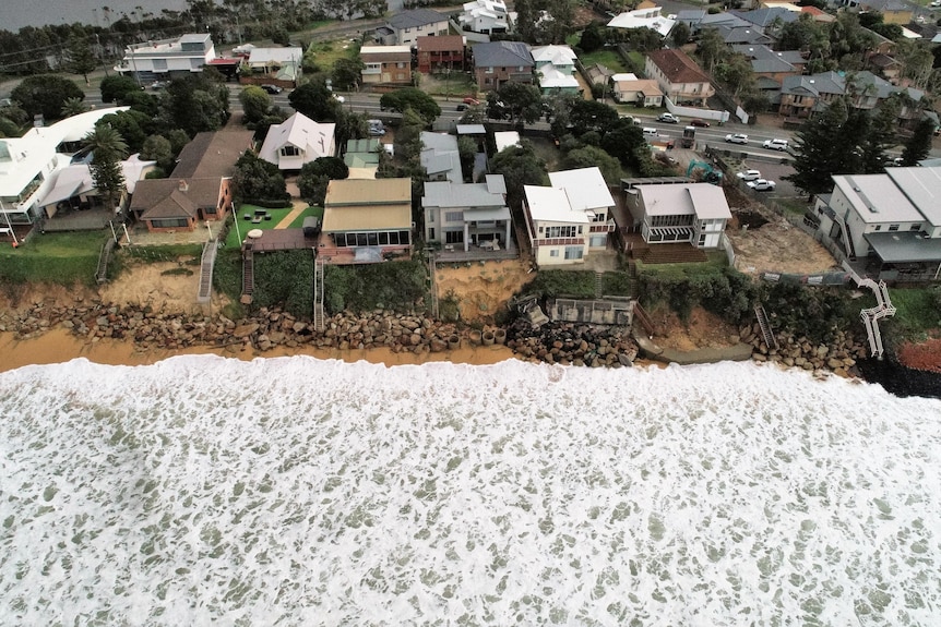 Vagues à proximité de maisons sur un front de mer.