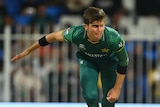 A Pakistan fast bowler is pictured mid-air in his follow through from a delivery at the T20 World Cup.