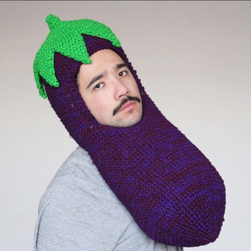 Chili Philly wearing a crocheted eggplant hat.