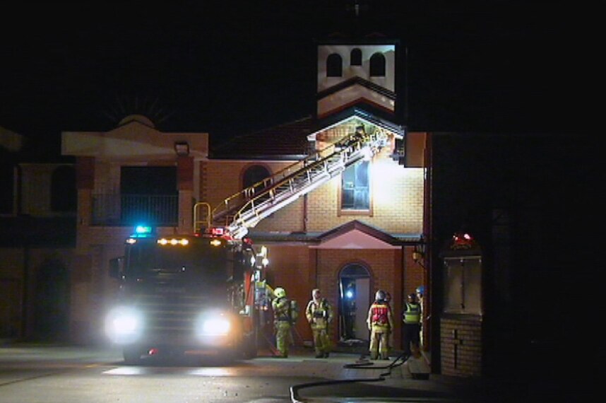 Fire crews and a truck work to put out a fire at a church in Preston