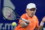 Tennis player Alex de Minaur hits a forehand during a Mexican Open match against Stefanos Tsitsipas.