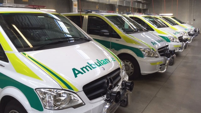 Ambulance vehicles lined up in an emergency station.