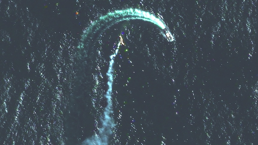 Satellite image shows a trail of smoke nearby a moving ship.
