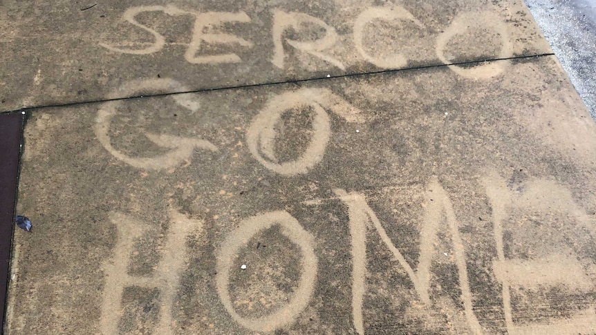 Graffiti reads "SERCO go home" on a Christmas Island footpath.