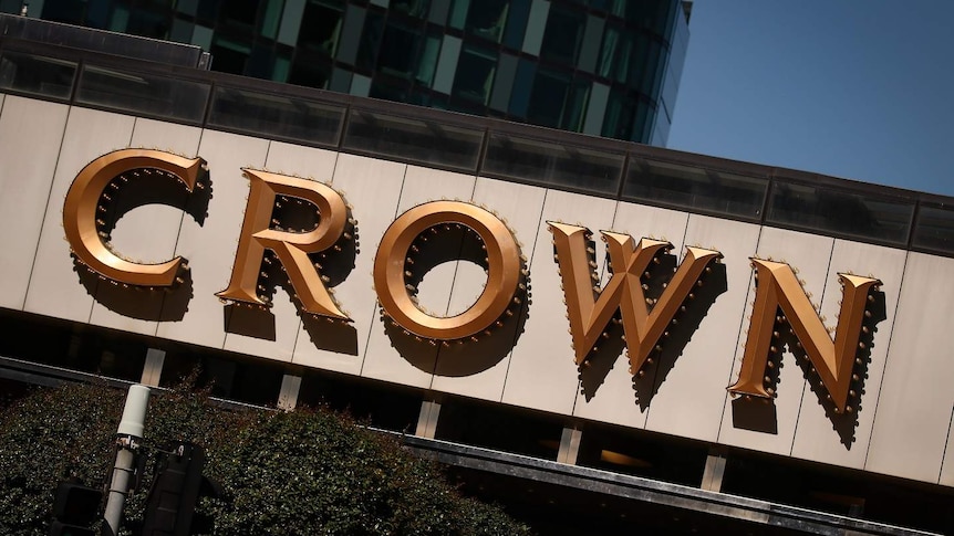 A sign saying 'Crown' on a building on a sunny day.