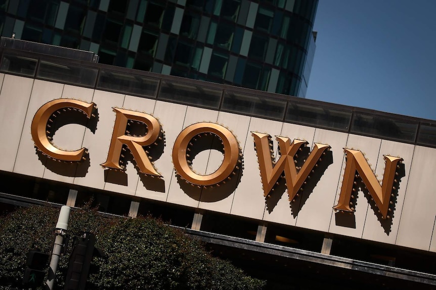 A sign saying 'Crown' on a building on a sunny day.