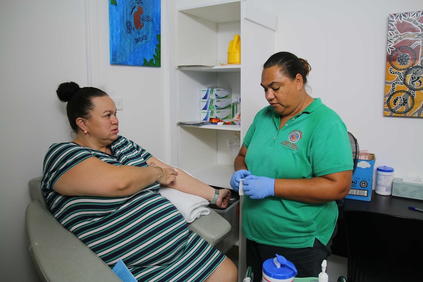 Indigenous research coordinator Loretta Weatherall collects a blood sample from a pregnant mother.