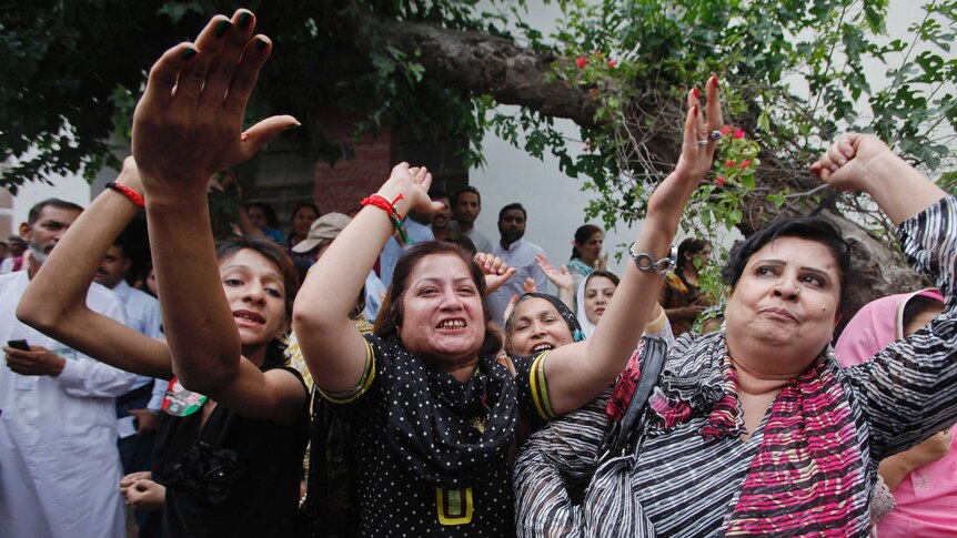 Supporters of Nawaz Sharif celebrate as he arrives to cast his vote in Lahore