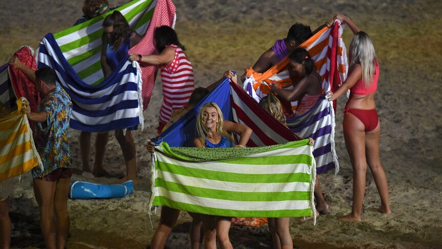 Performers demonstrate using towels as a makeshift changing room at the Commonwealth Games opening ceremony.