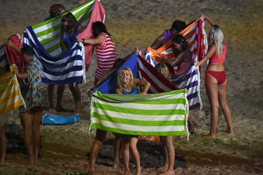 Performers demonstrate using towels as a makeshift changing room at the Commonwealth Games opening ceremony.