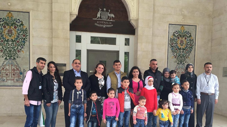 Members of Iraqi and Syrian families line up for a photo in Jordan