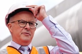 Anthony Albanese wears high-vis and a hard hat.