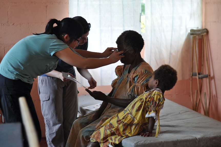 volunteer fitting glasses on a women  