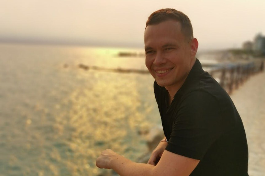 A portrait of Oleg Sashchenko on a pier at sunset. 